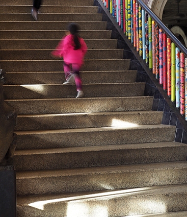 Girl running up main staircase